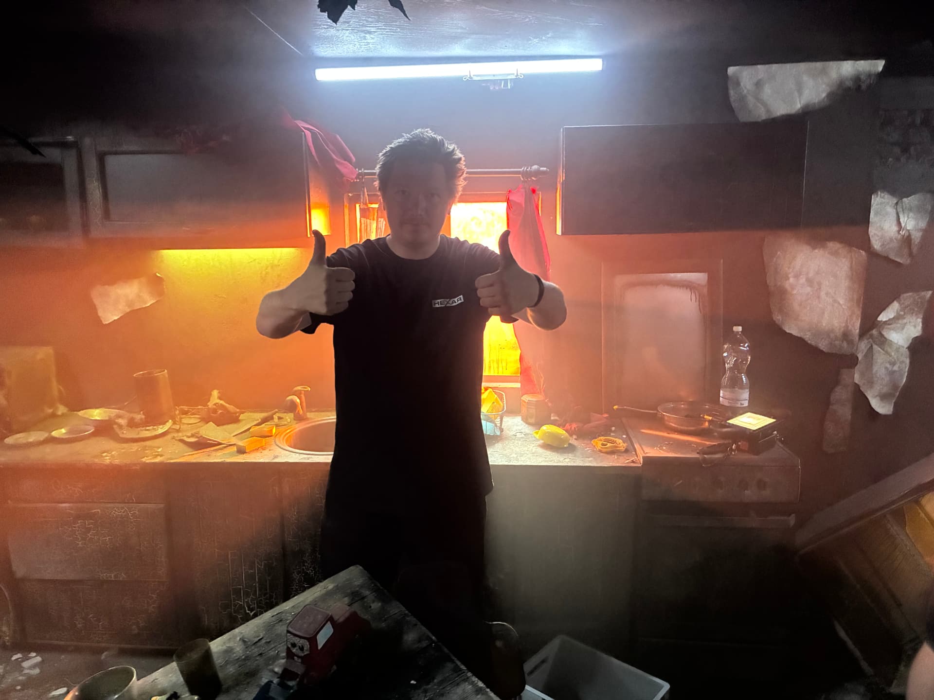 Crew member giving two thumbs up in the burned kitchen set