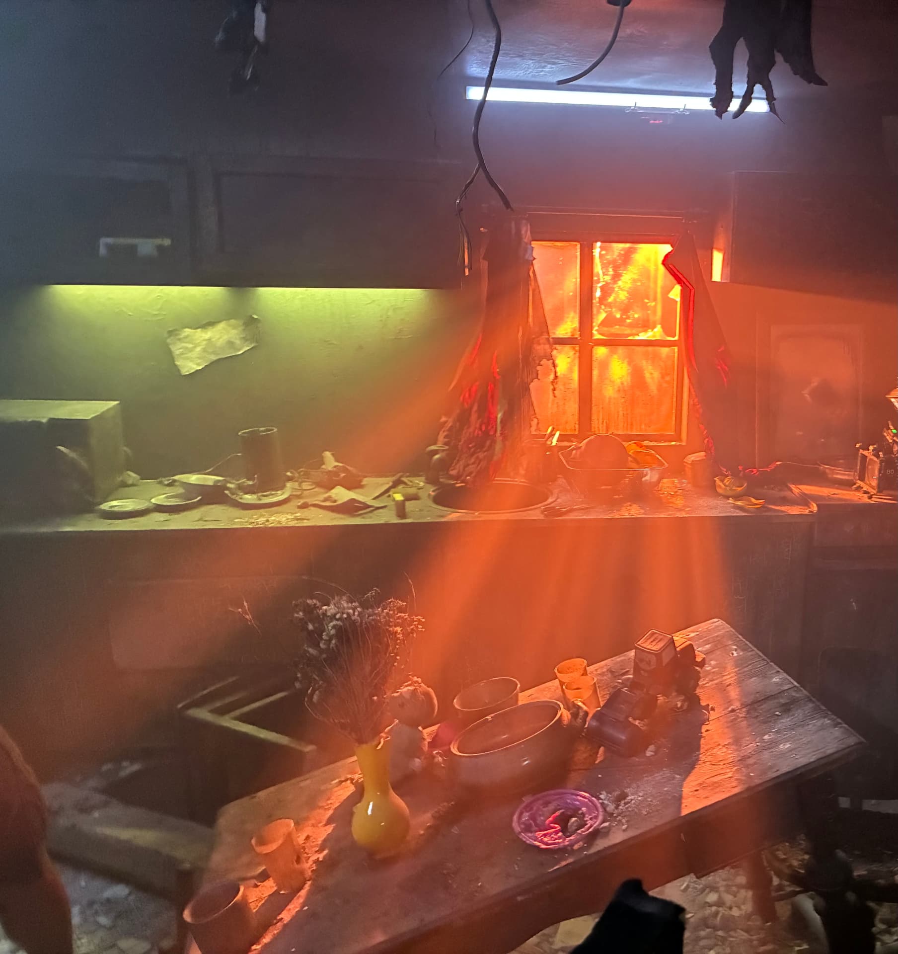 Firelight streaming through the window of the burned kitchen set