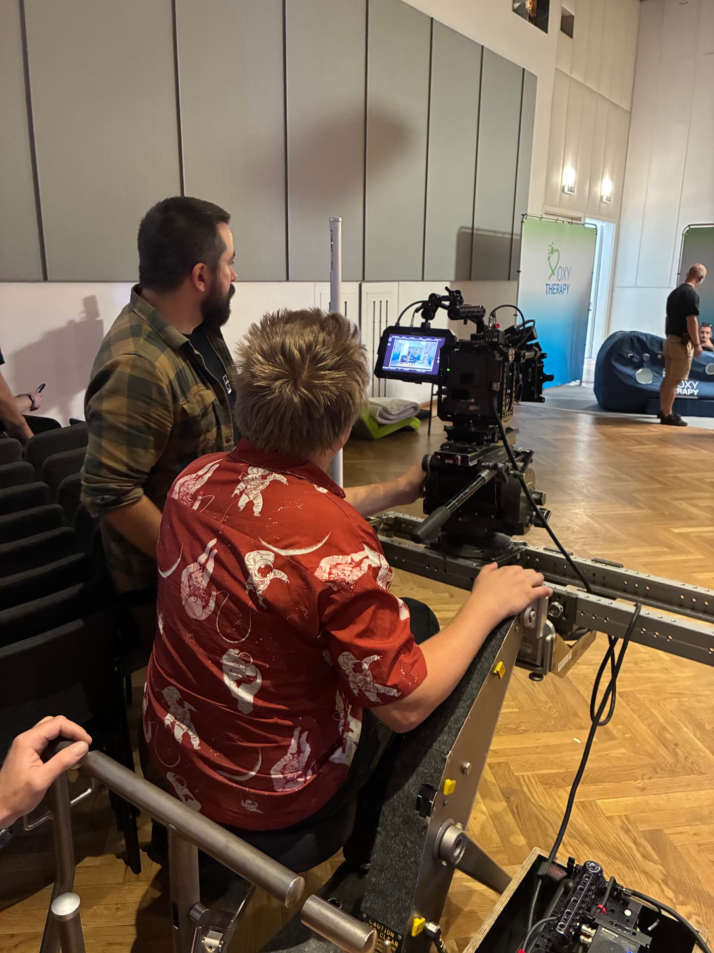Camera operator and focus puller working a dolly move in the hall location