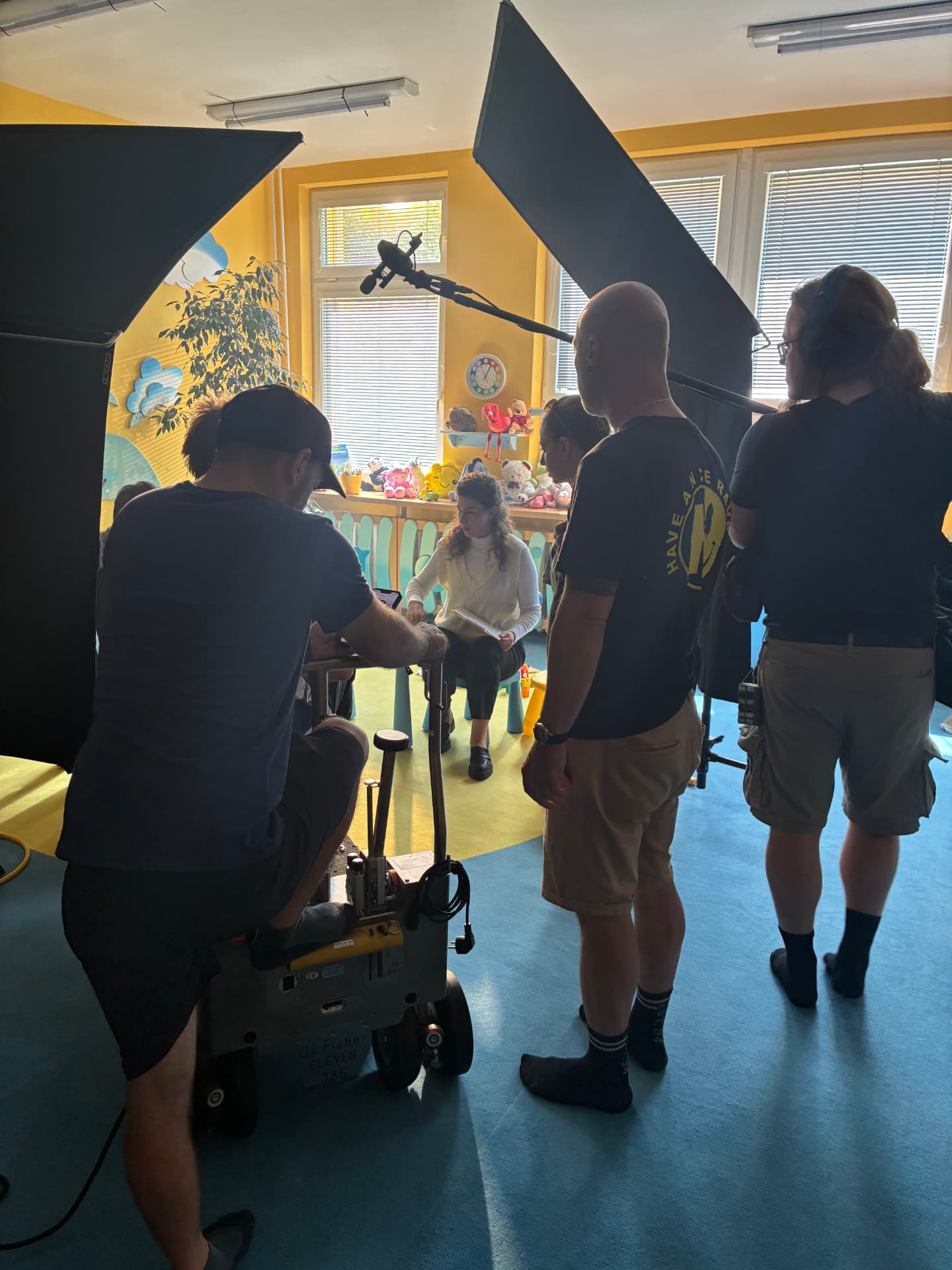 Crew lighting an interview scene in a bright children's playroom